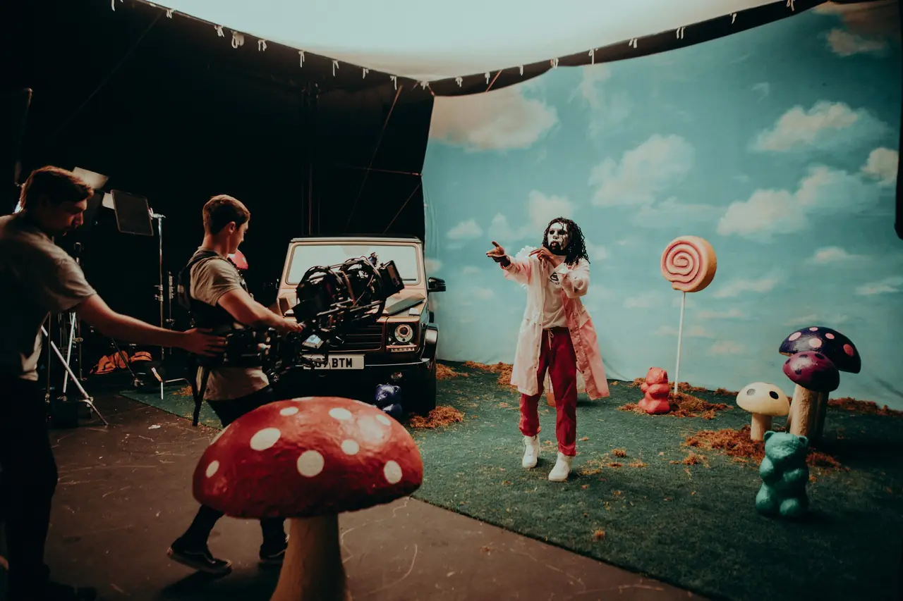 Behind the scenes on a surreal set with a giant mushroom and a performer