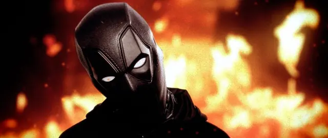 Masked figure in front of flames