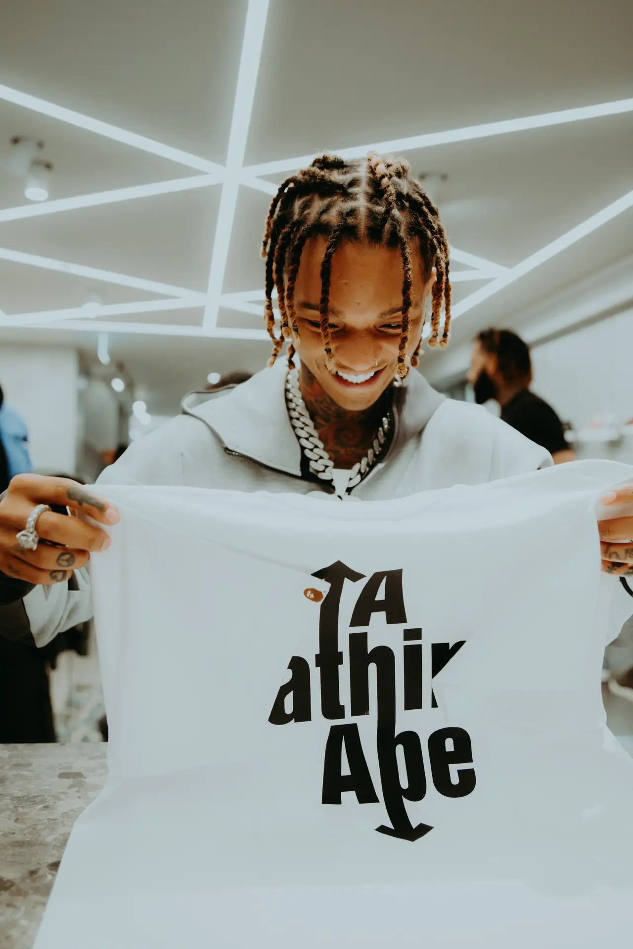 Artist smiling while holding up a printed T-shirt